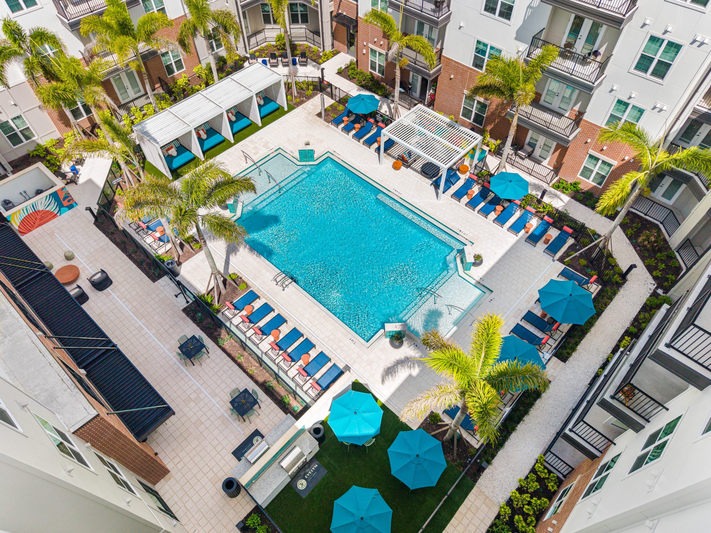 Aerial view of the palm-lined pool courtyard at Evelyn City Lofts